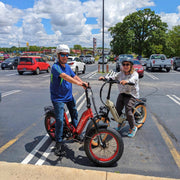 Two riders with Vtuvia SX20 folding e-bikes in a parking lot